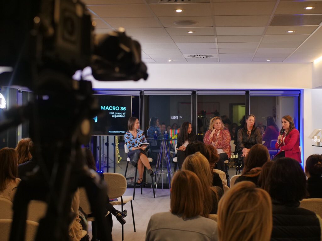 Imagen de un evento titulado 'MACRO 36: Del plano al algoritmo', donde Susana Quintás participa como panelista junto a otras profesionales. La fotografía muestra una mesa redonda en un ambiente profesional y dinámico, con un enfoque en temas de tecnología, sostenibilidad y transformación digital. En el fondo, se observa una pantalla con el título del evento, destacando el diálogo enriquecedor entre las panelistas y el público presente